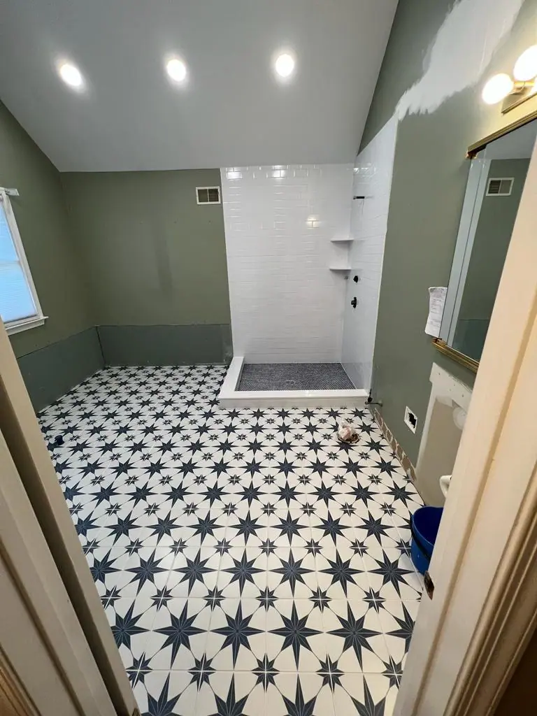 Black and white star-pattern floor tile in a remodeled bathroom