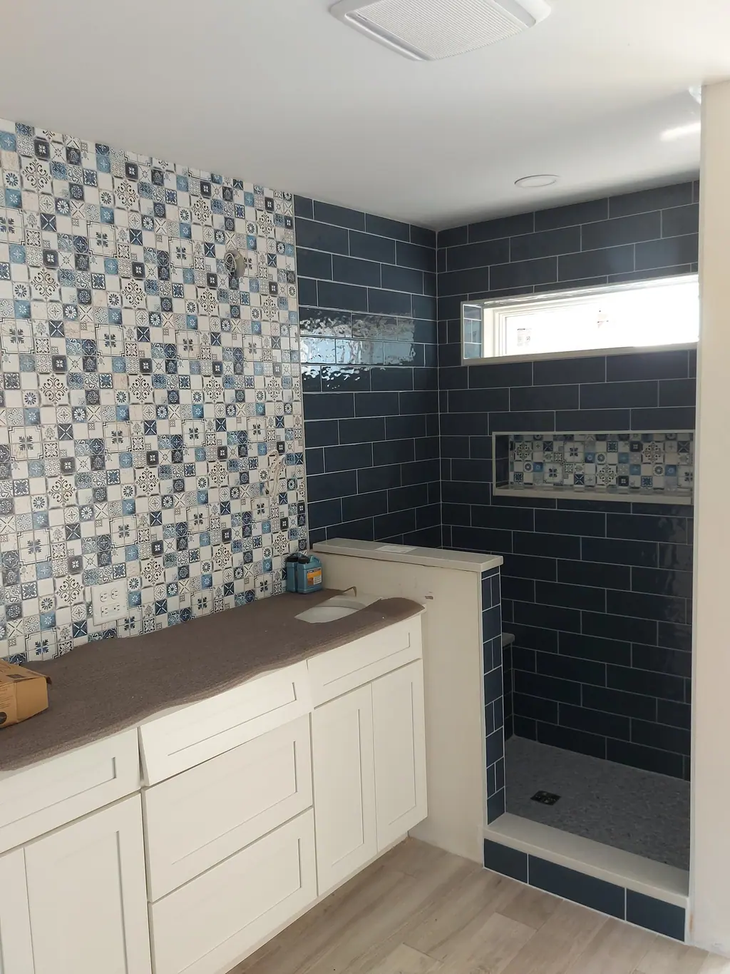 Bathroom with navy subway shower and patterned cement-look accent wall