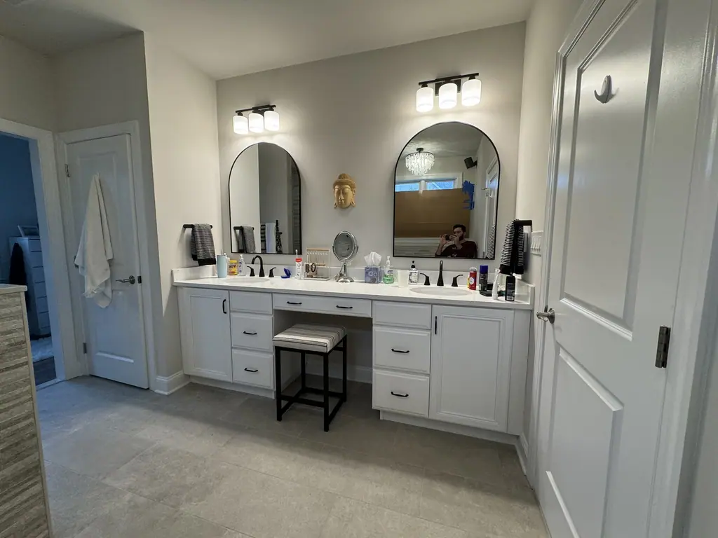 Double vanity with makeup station, arched mirrors and large-format floor tile