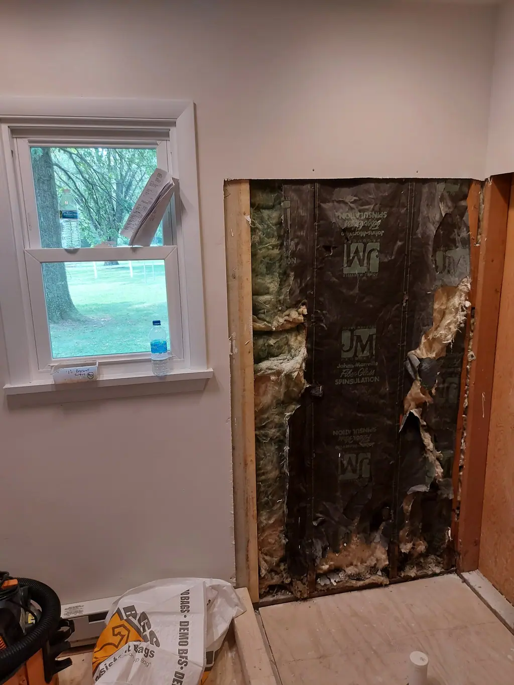 Exterior bathroom wall opened, exposing old water damage