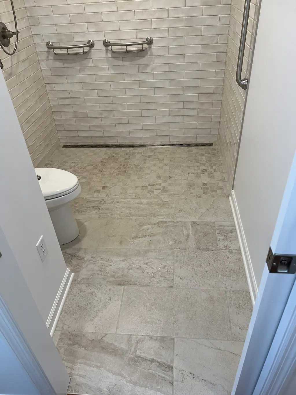 Curbless shower with linear drain and grab bars for accessibility