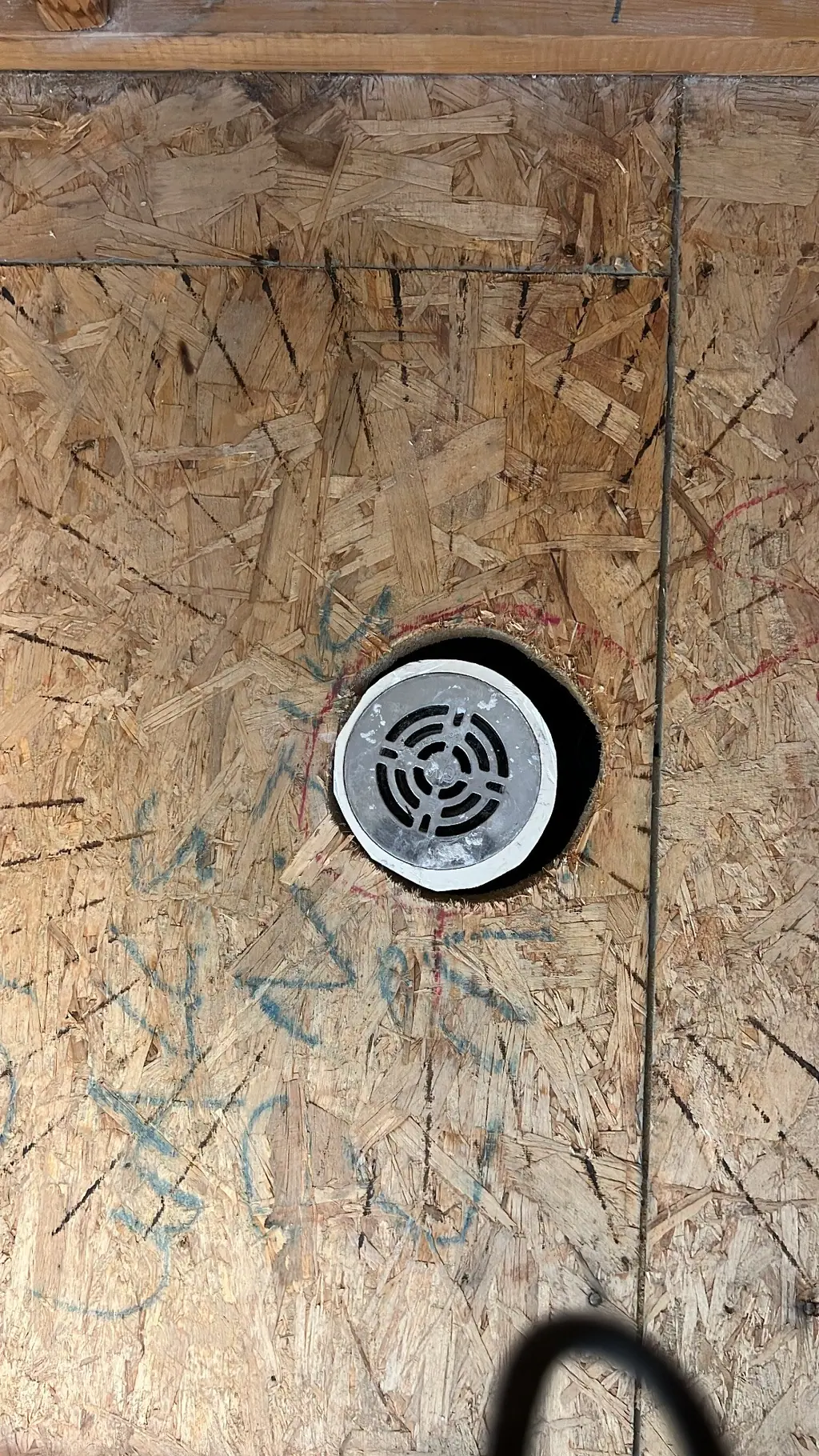 Shower area stripped to the subfloor around the drain