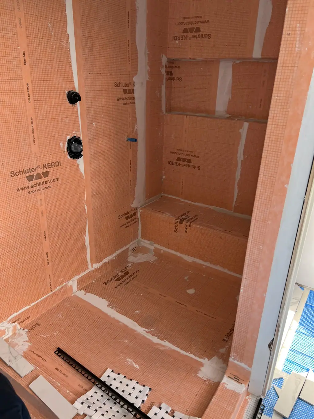 Shower with waterproofing membrane, bench and niche framed