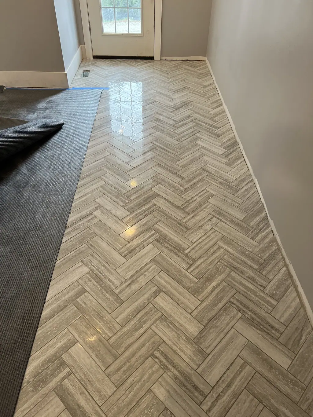 Herringbone wood-look tile in a long hallway